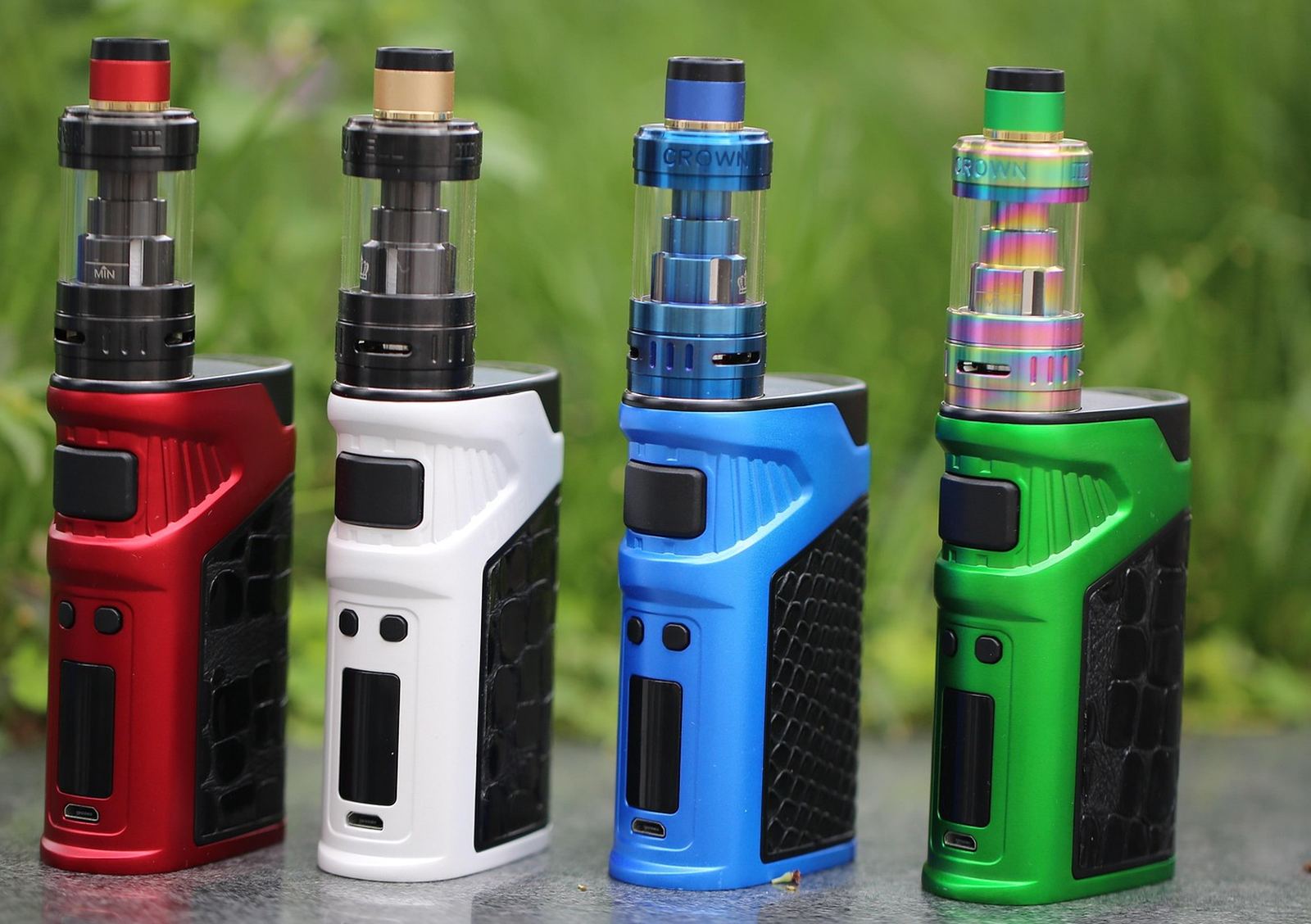 Four vape mods with tanks standing side by side.
